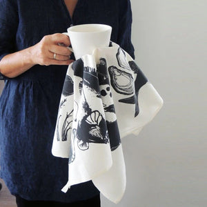 A person cleaning with a white Seafood tea-towel.