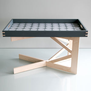 Modern coffee table with a gray dot tray on the large maple stand at the lower height.