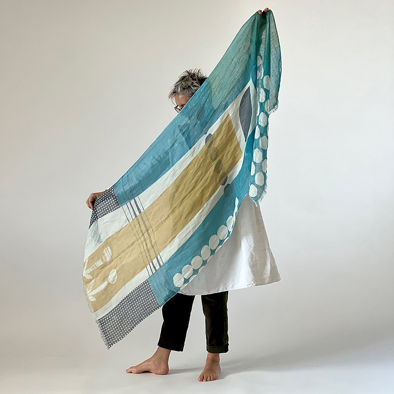 Banjo Coral large cotton linen scarf being styled, showing the large abstract design.