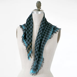 Littles Gus gingham merino wool silk neckerchief draped on a mannequin, showing four-sided fringe — © 2026 PilgrimWaters.