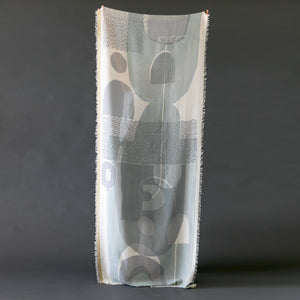 A scarf held up showing the complete abstract printed design called 'Sparrow.'